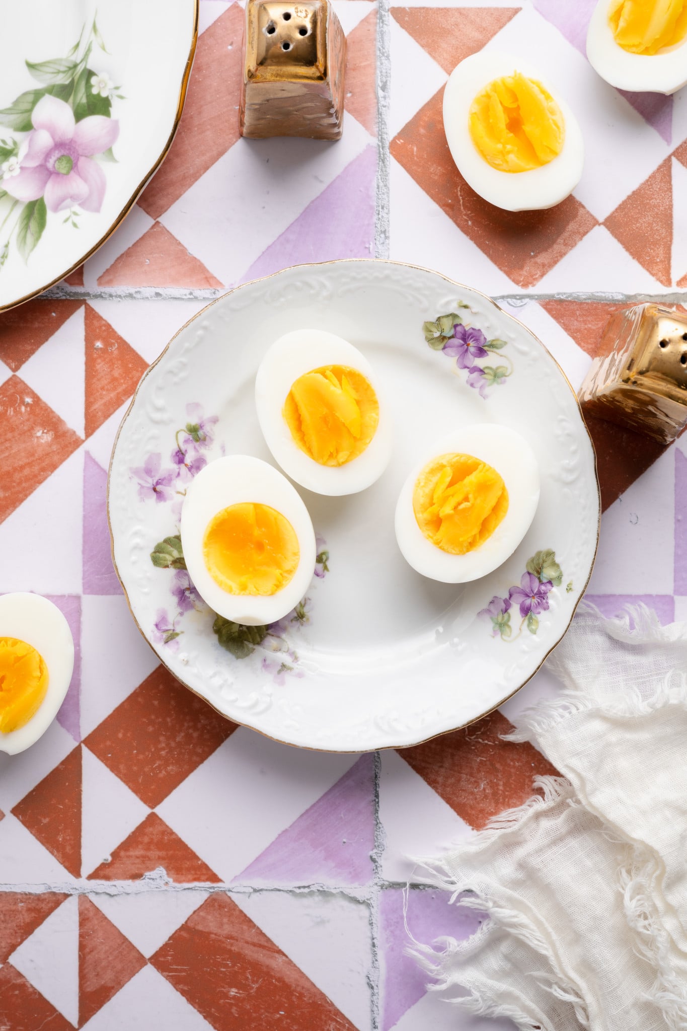 Three air fryer hard boiled eggs on a floral plate.