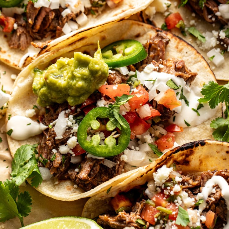 Beef barbacoa taco topping with fresh taco toppings.