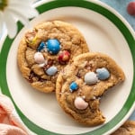 Two cadbury cookies on a plate with a bite taken out of one of the cookies.