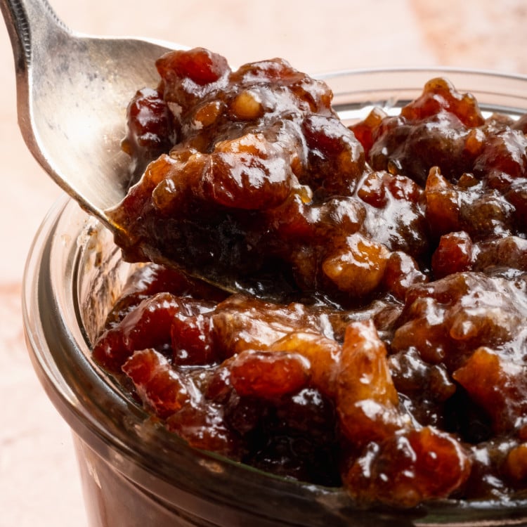 Spoon digging into jar of bacon jam.