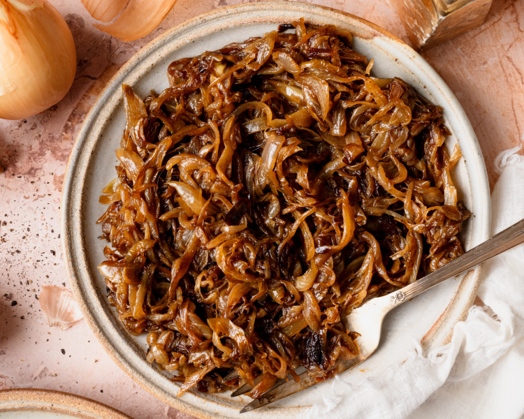 Caramelized onions finished and served on a plate with a fork.