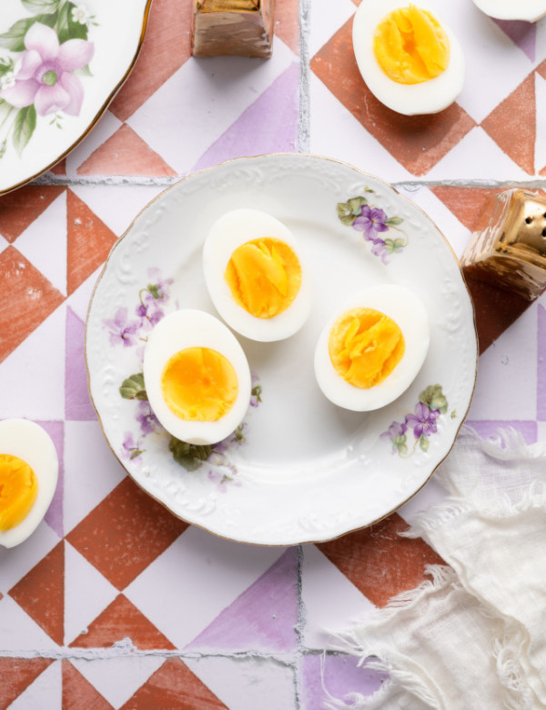 Three air fryer hard boiled eggs on a floral plate.