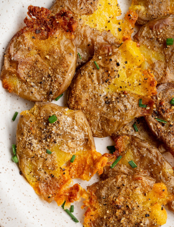 Crispy smashed potatoes garnished with fresh herbs.