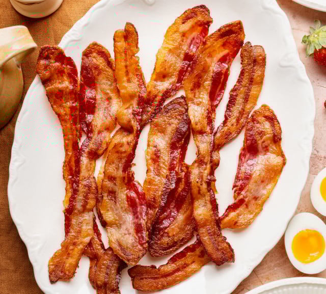 Bacon cooked and served on white plate.