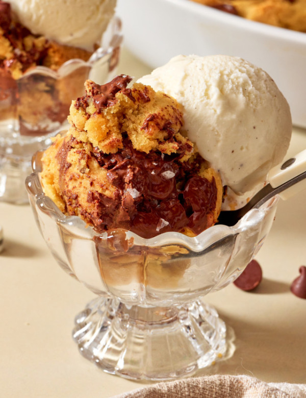 Scoopable cookies served in a small bowl dish with scoop of vanilla ice cream and a spoon.