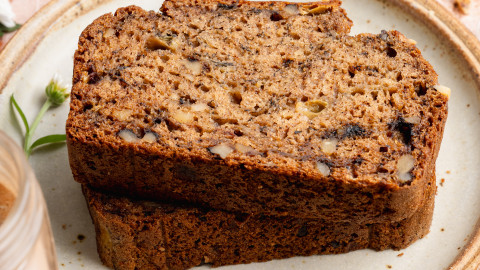 Two slices of healthy banana bread stacked on top of each other and served on a small plate.