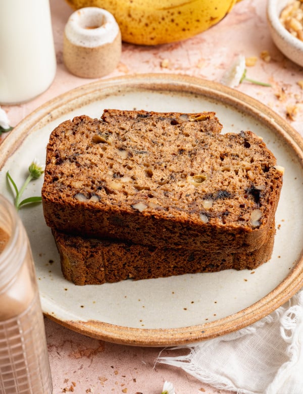 Two slices of healthy banana bread stacked on top of each other and served on a small plate.