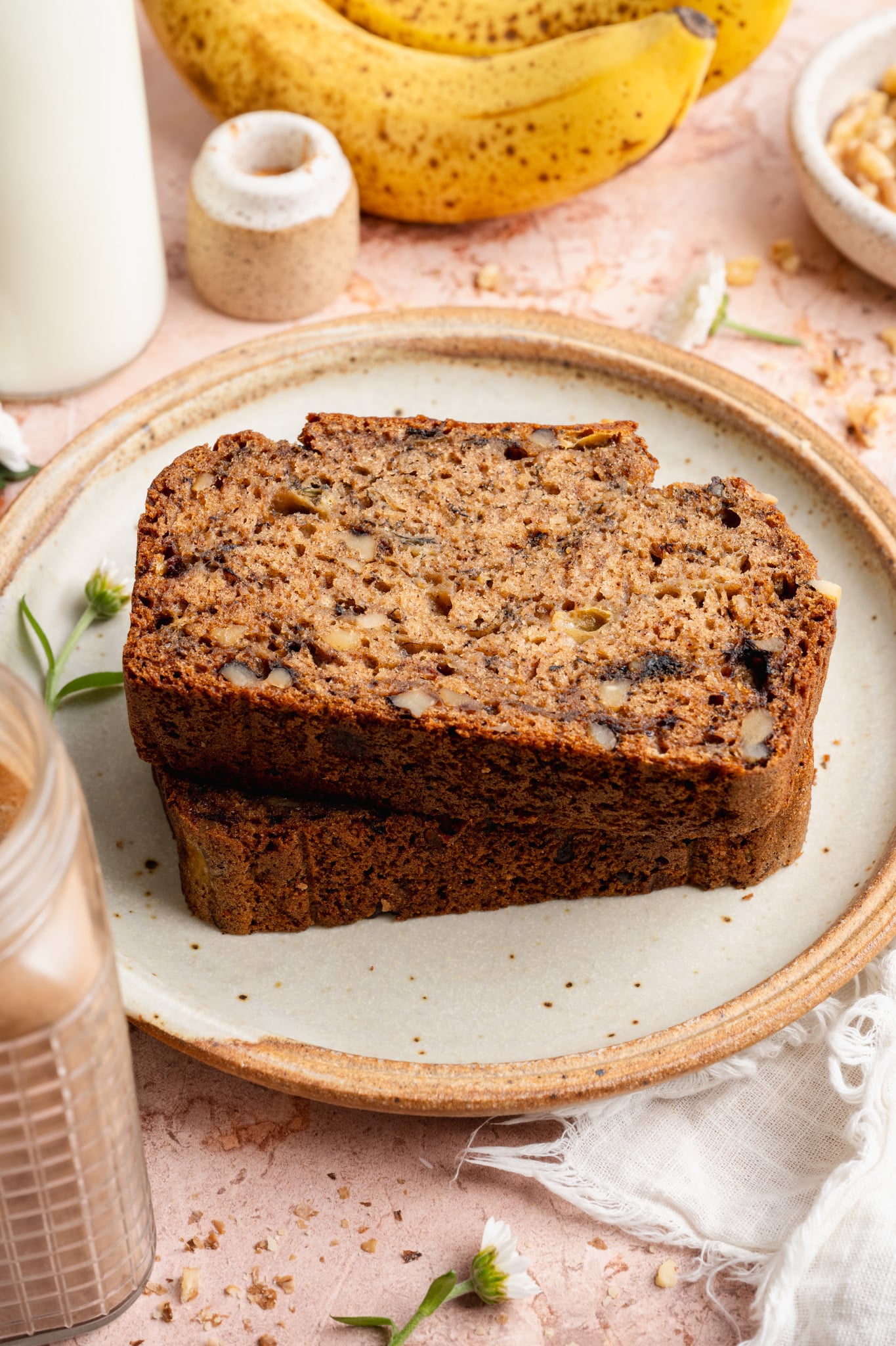 Two slices of healthy banana bread stacked on top of each other and served on a small plate.
