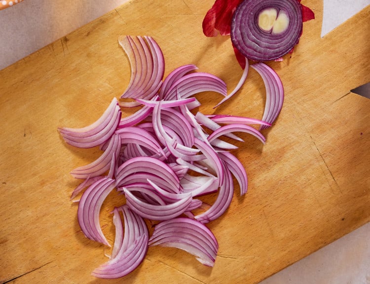 Image showing a julienned cut onion on a cutting board.