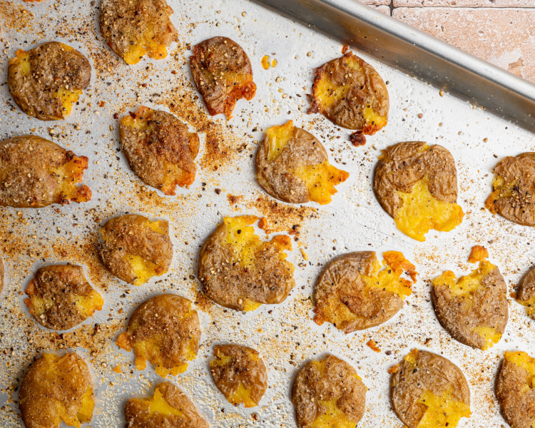 Crispy smashed potatoes on baking sheet.