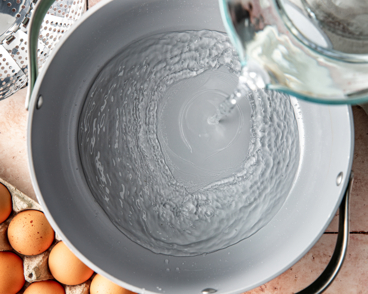 Adding the water to the bottom of the large pot.