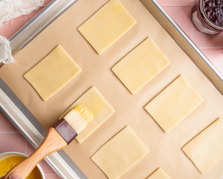 Brushing each dough rectangle with egg wash.