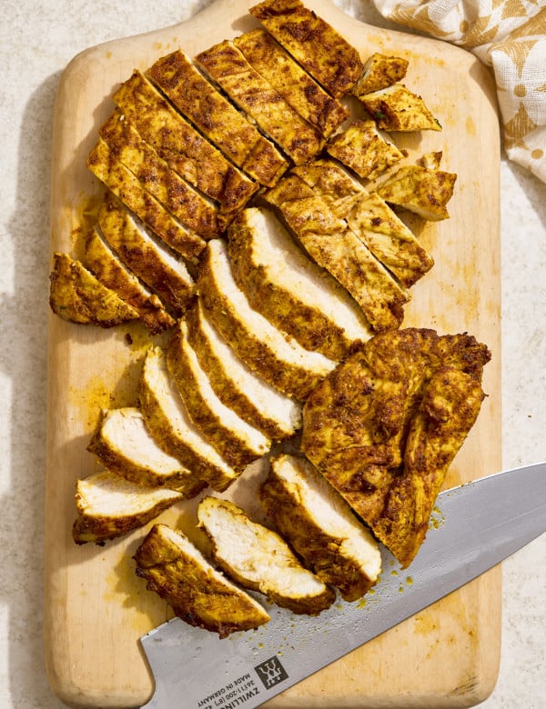 Air fryer chicken shawarma sliced on a wooden cutting board after cooking and resting.