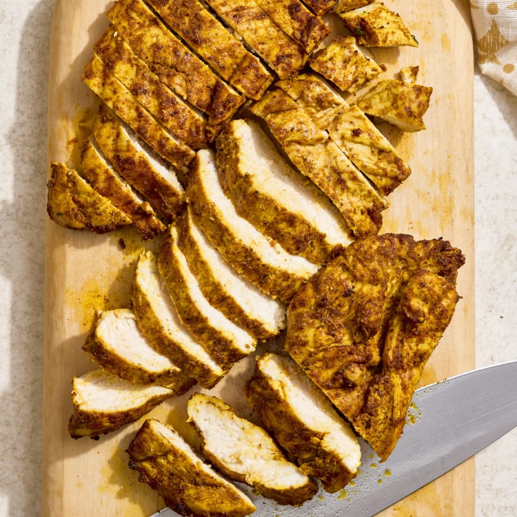 Air fryer chicken shawarma sliced on a wooden cutting board after cooking and resting.