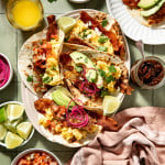Loaded breakfast tacos assembled on large serving plate.