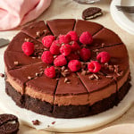 No-bake chocolate cheesecake sliced and topped with fresh raspberries and chocolate shavings.