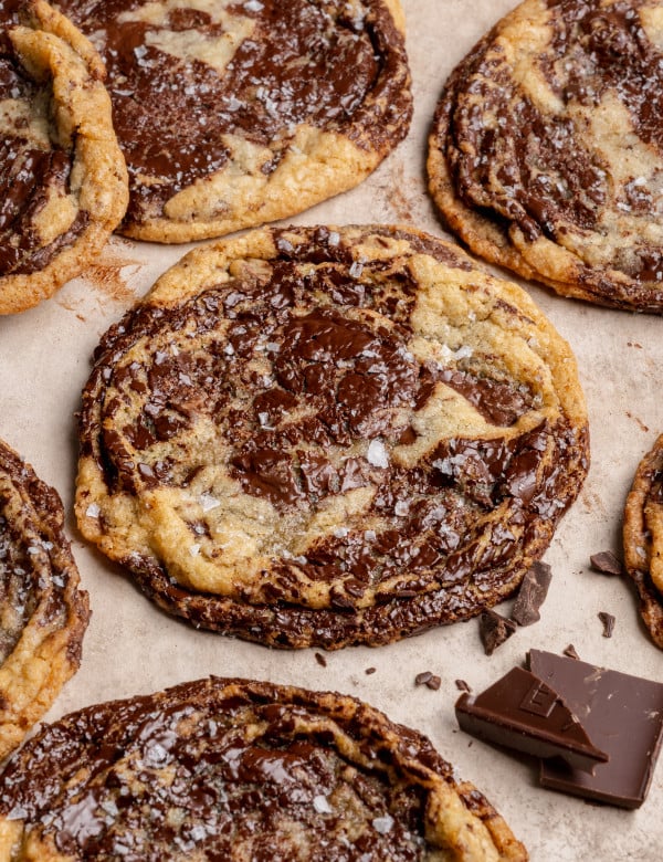 Pan banging chocolate chunk cookies baked and garnished with flaky sea salt.