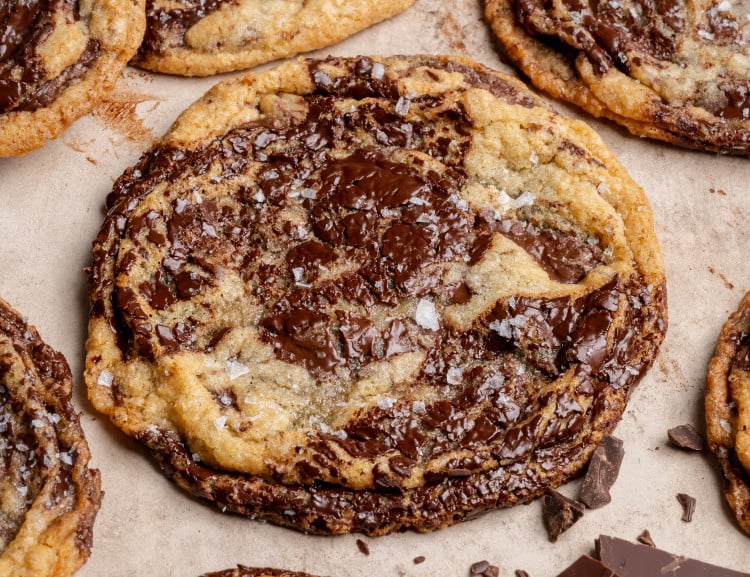 Pan banging chocolate chunk cookies baked and garnished with flaky sea salt.