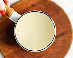 Warming the heavy cream in a small saucepan until it's simmering but not boiling.