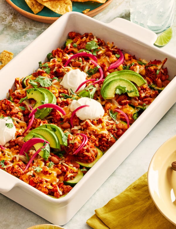 Ground turkey taco zucchini boats topped with sour cream, avocado and pickled red onions.