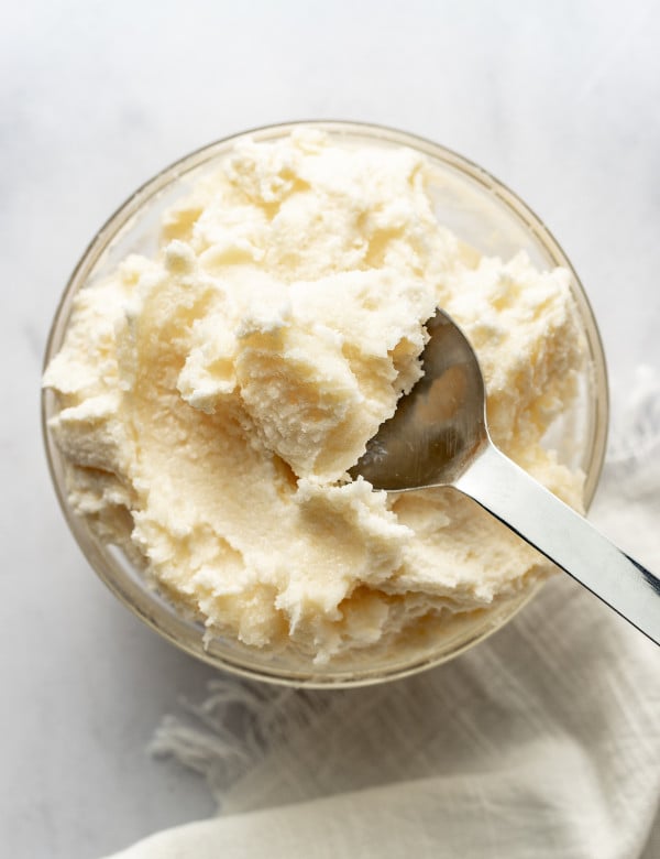 Spoon picking up creamed butter and sugar out of bowl.