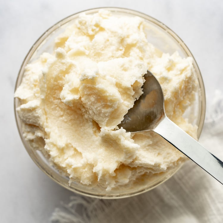 Spoon picking up creamed butter and sugar out of bowl.