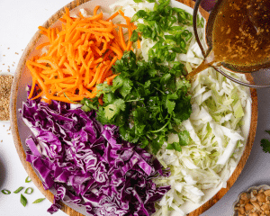 Pouring dressing over slaw.