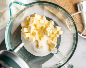 Cubed softened butter and sugar in stand mixer bowl.