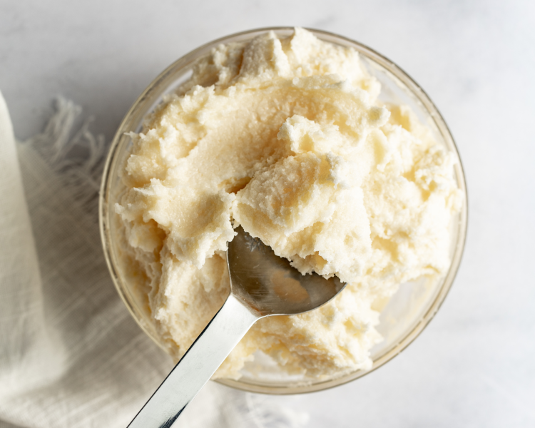 Spoon scooping up creamed butter and sugar.