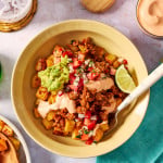 Potato taco bowl with all the toppings and a fork digging into the bowl.