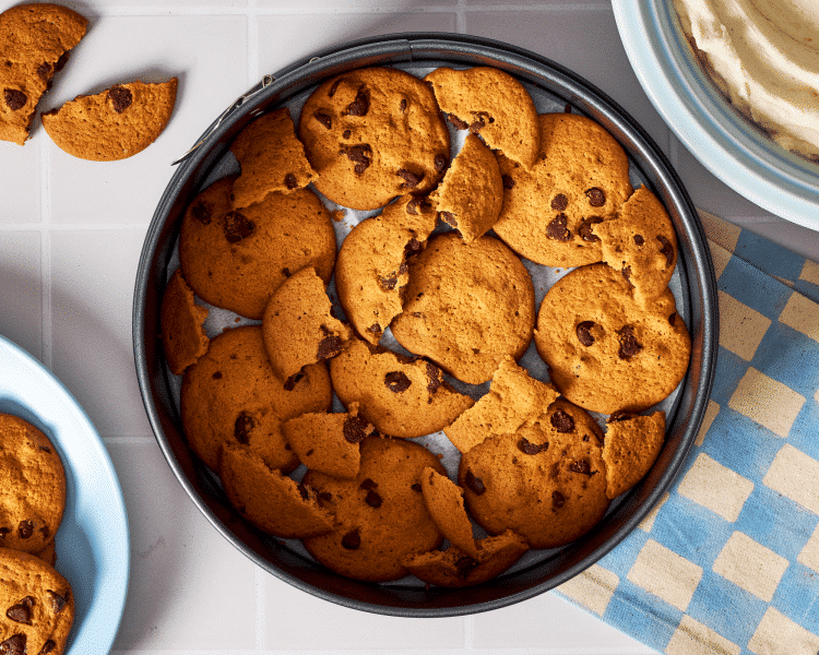Putting cookies on the bottom of the springform pan as the first layer.