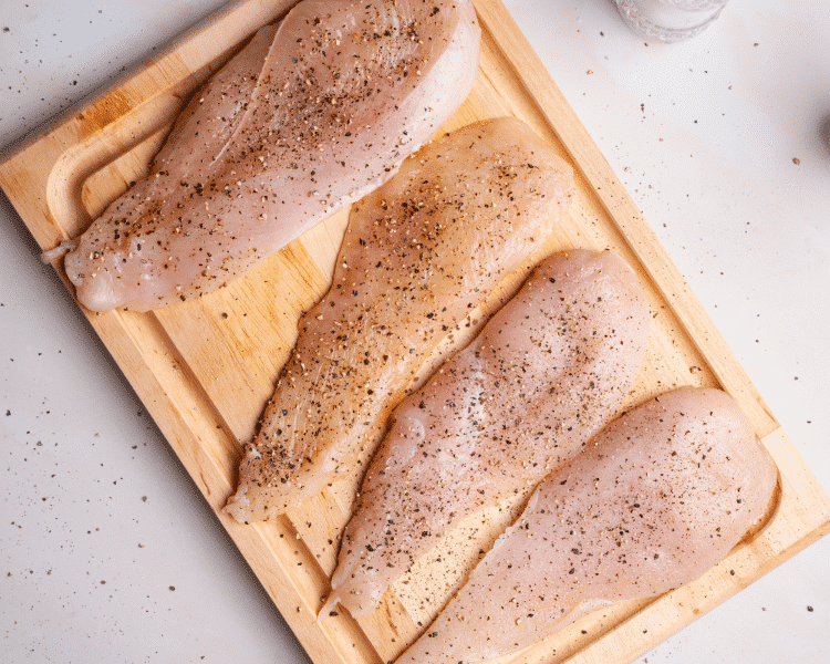 Seasoning sliced and pounded chicken with kosher salt and black pepper before dredging.