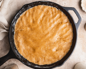 Snickerdoodle cookie dough pressed into cast iron skillet.
