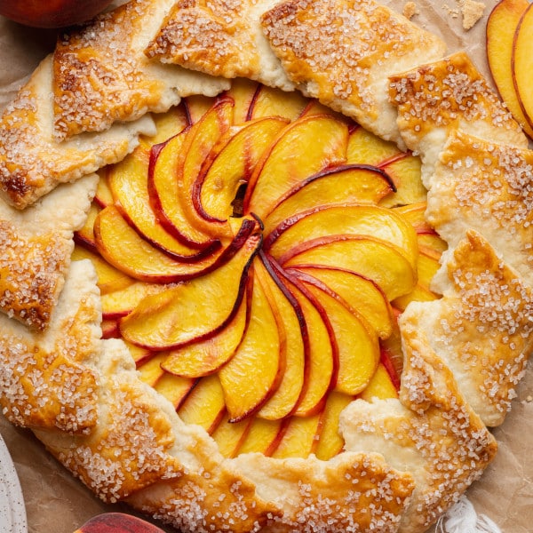 Peach galette baked on parchment paper.