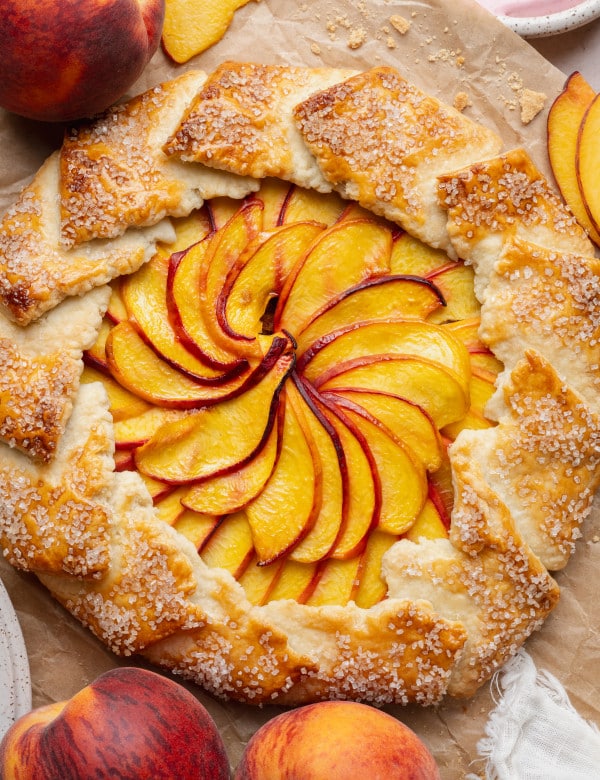 Peach galette baked on parchment paper.