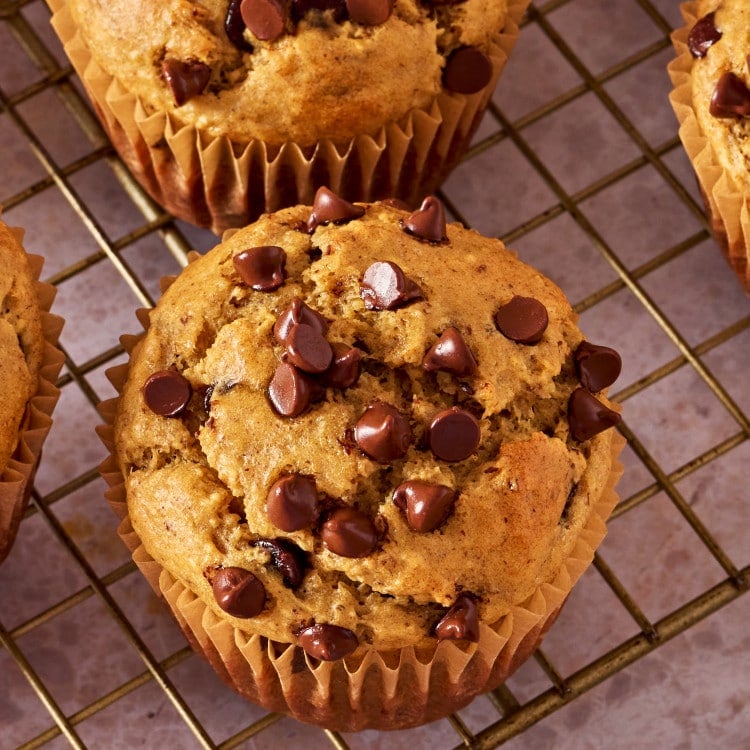 Blender banana muffin cooling on a wire rack.