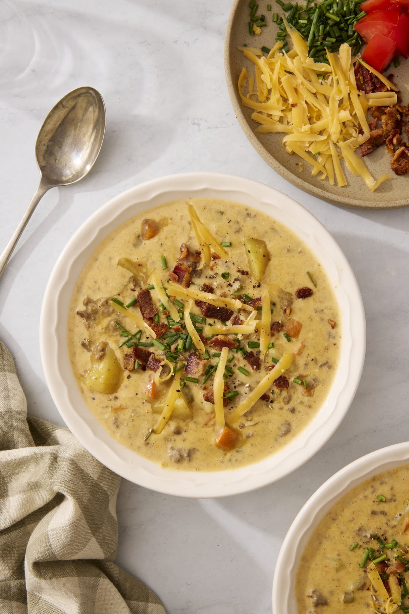 Cheeseburger soup served in a bowl with toppings.
