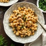 One-pot chicken mac and cheese served in a bowl with fresh parsley with fork on the side.