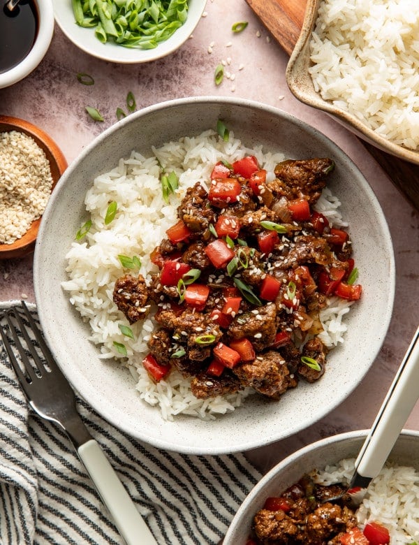 Honey garlic beef served over warm rice in a bowl.