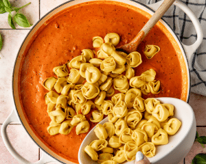 Adding cheese tortellini into sauce and beef mixture.