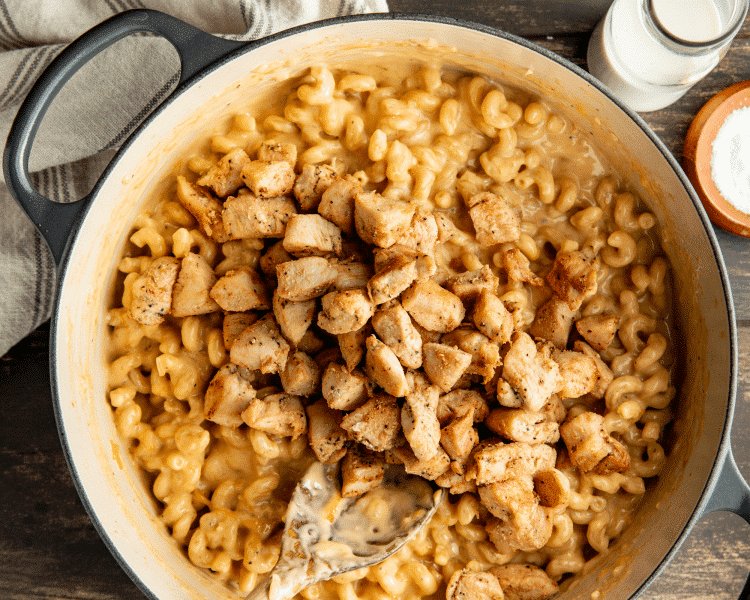Adding the cooked chicken back in to mac and cheese.