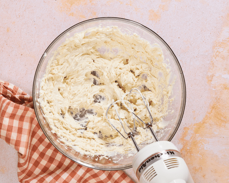 Beating the solidified butter into the cream cheese.