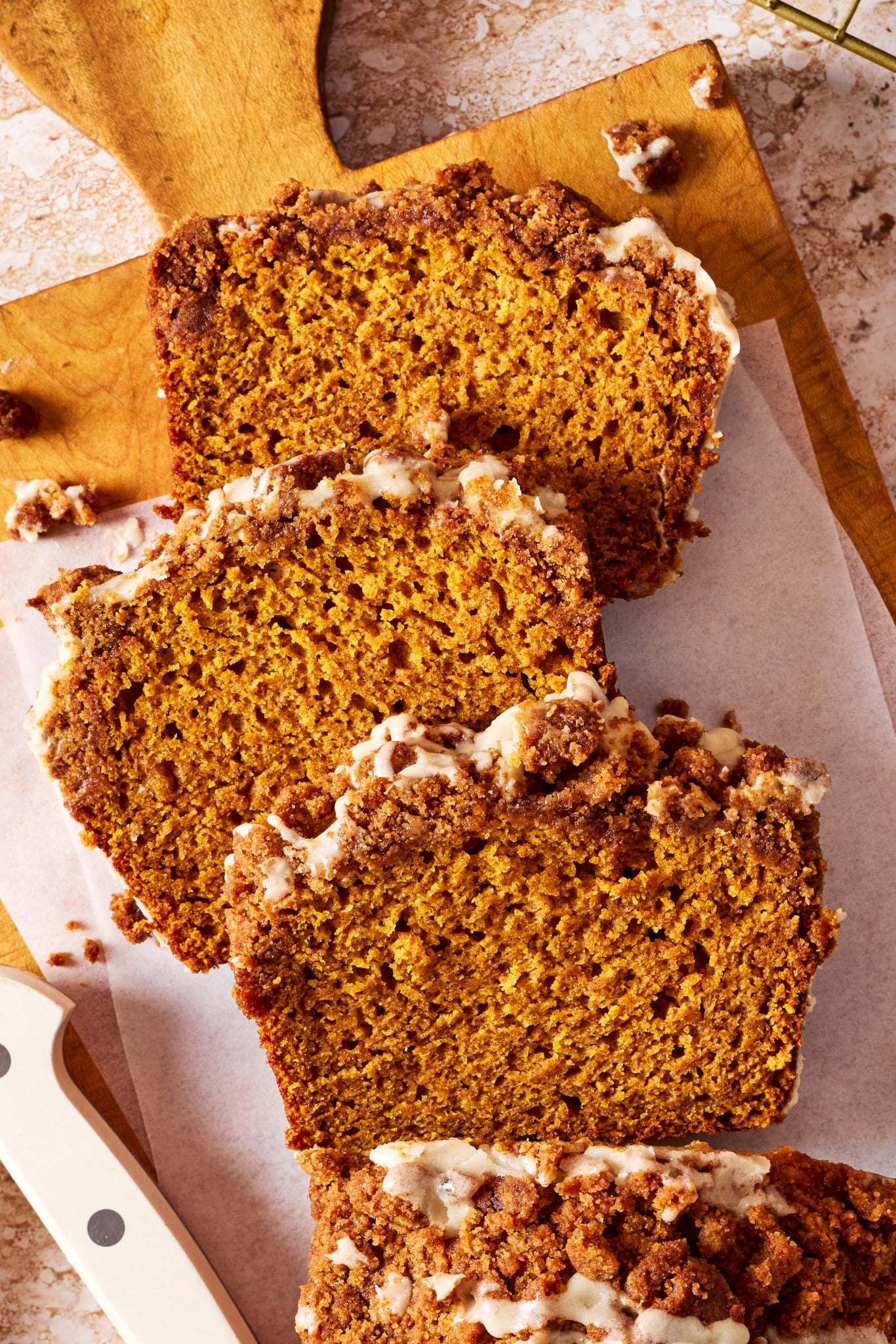 Sliced Pumpkin Streusel Bread showing the soft, moist pumpkin crumb with a thick streusel topping and vanilla glaze.