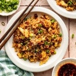 Chili crisp fried rice served on a plate with chopsticks on the side.