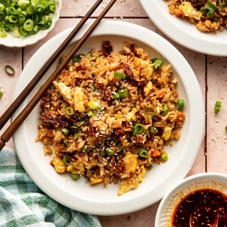 Chili crisp fried rice served on a plate with chopsticks on the side.