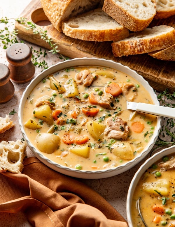 Hearty chicken stew served in a bowl with a spoon on the side.