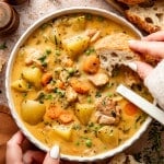 Dipping a piece of crusty bread into chicken stew.