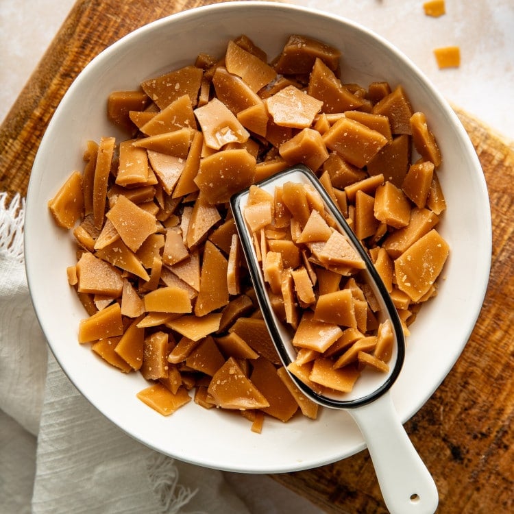 Scoop digging into bowl of homemade toffee bits.