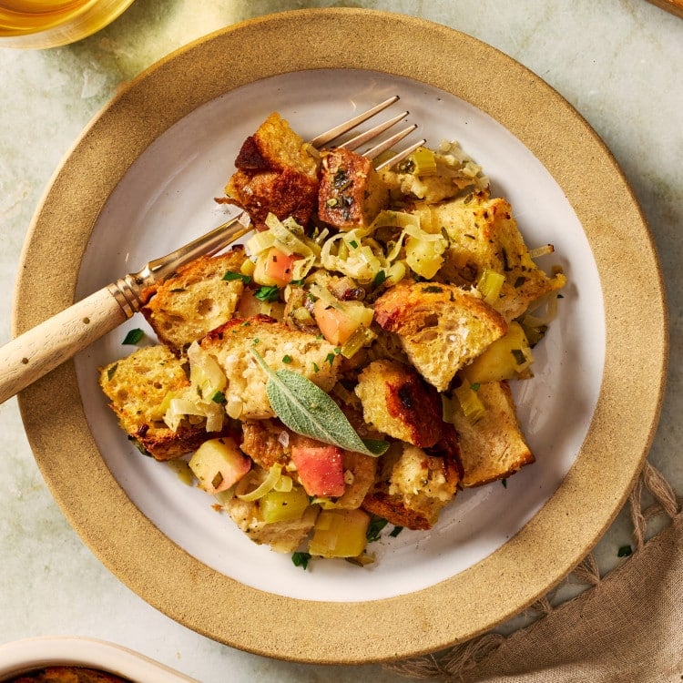 Leak and sage sourdough stuffing served on a plate with a fork.