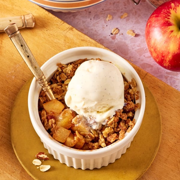 Single serve apple crisp served with a scoop of vanilla ice cream.
